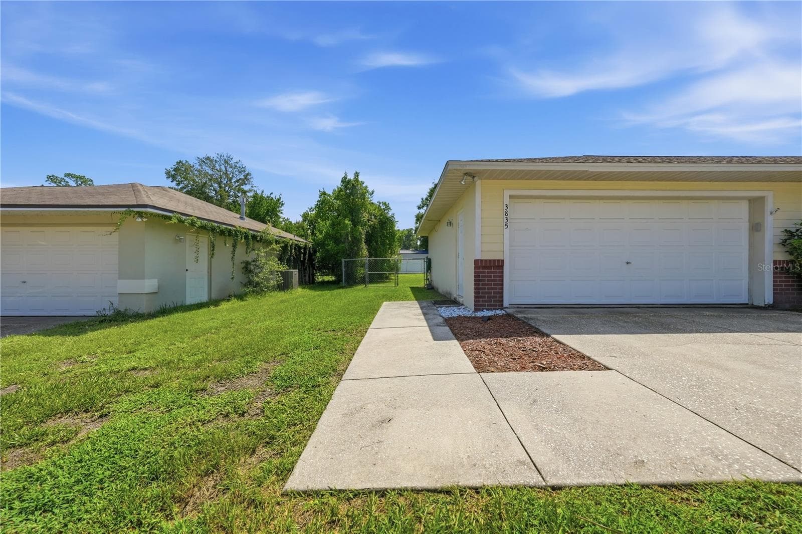 Walkway to side garage door and fenced backyard. - 3835 NE 13TH AVE, OCALA