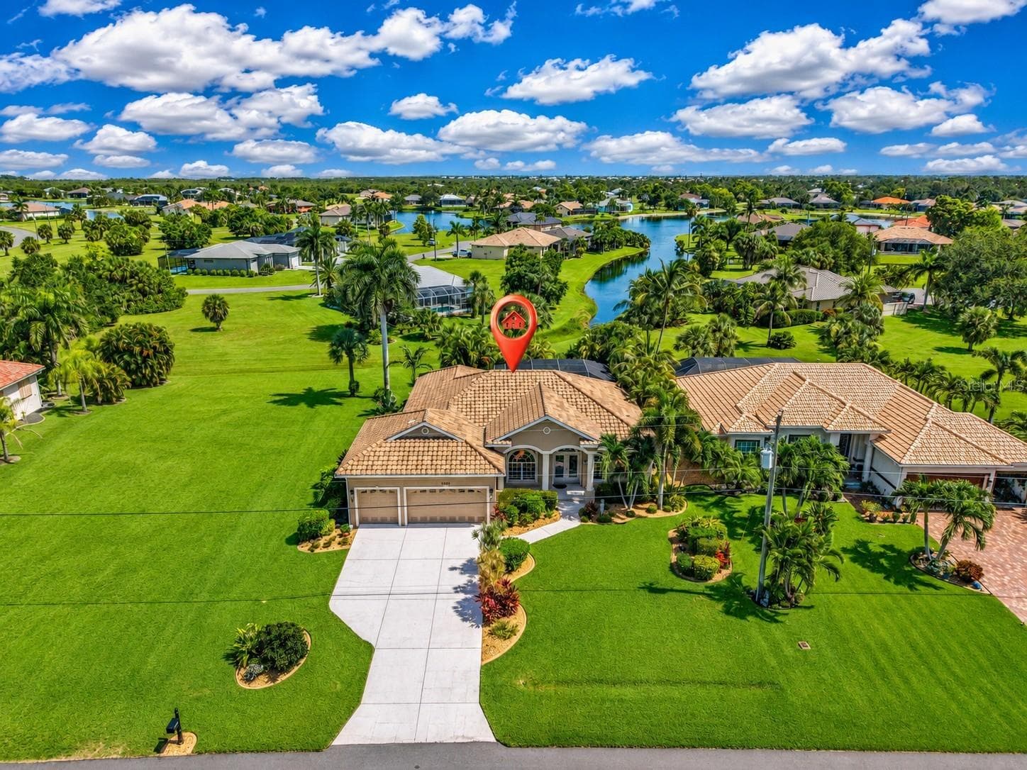 Beautifully positioned beside an expansive greenbelt, this home enjoys a picturesque long view across tropical landscaping toward the winding waterways of Burnt Store Lakes - 24228 PEPPERCORN RD, PUNTA GORDA