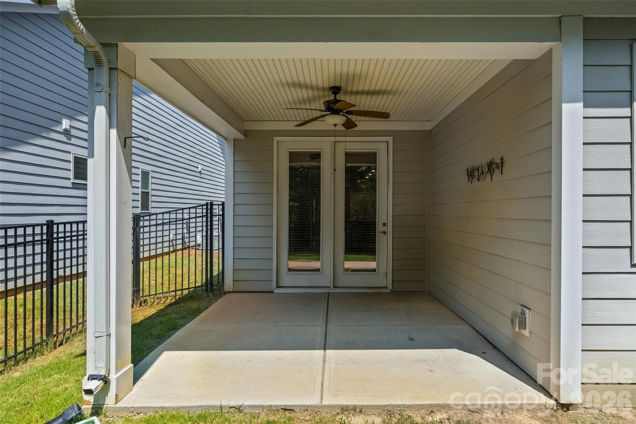 Covered back porch/patio offers the perfect balance of sunshine and shade, creating a comfortable outdoor retreat overlooking the fenced backyard-ideal for morning coffee or evening relaxation. - 596 Rustlewood Way, Rock Hill