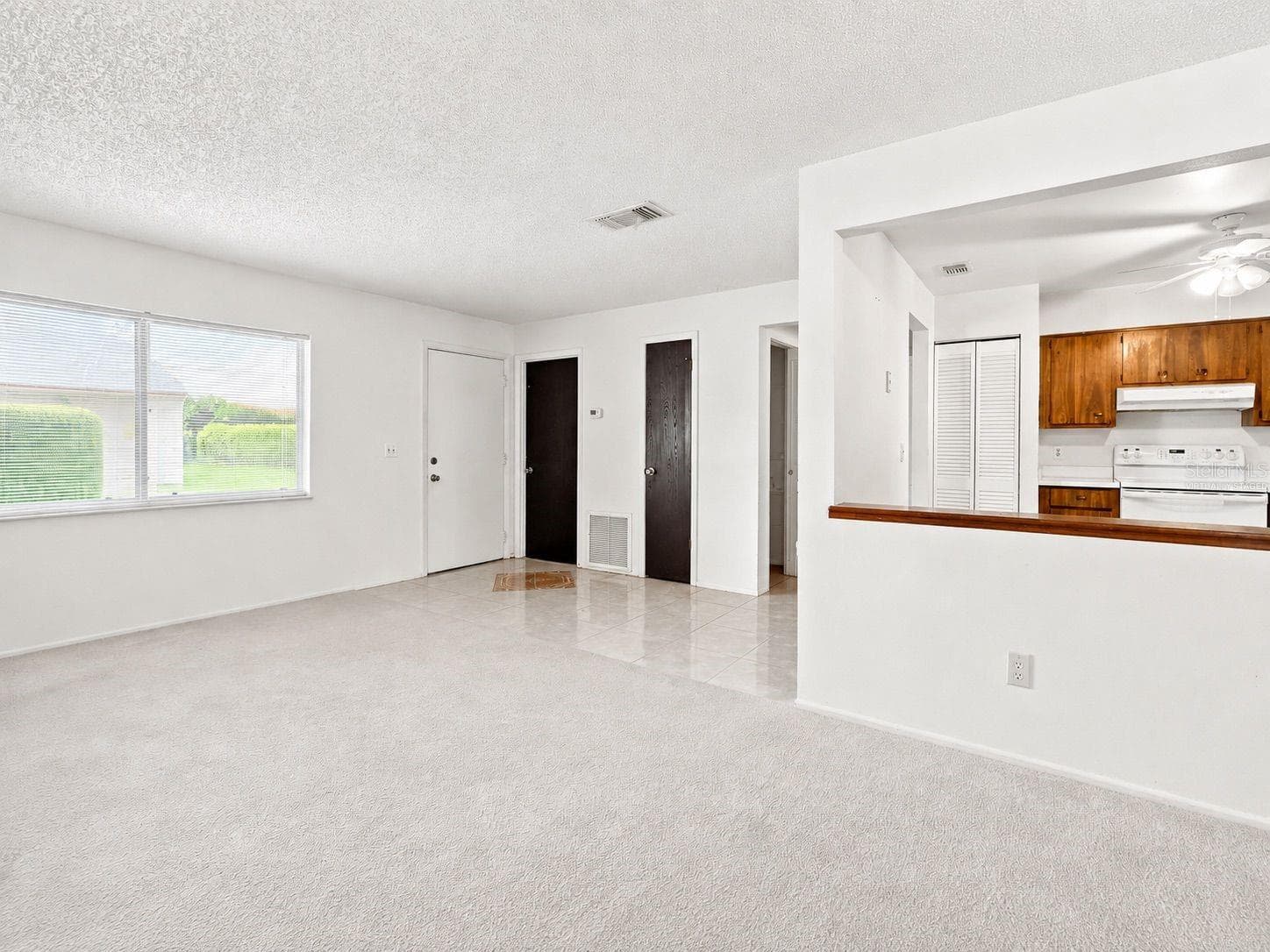 Virtually staged living room and kitchen - 1418 CATALINA BLVD, DELTONA