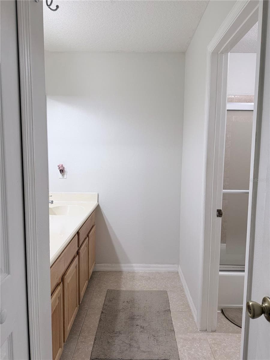 The spacious secondary bathroom features a double-sink vanity and a convenient linen closet for added storage. - 142 BRIGHTVIEW DR, LAKE MARY