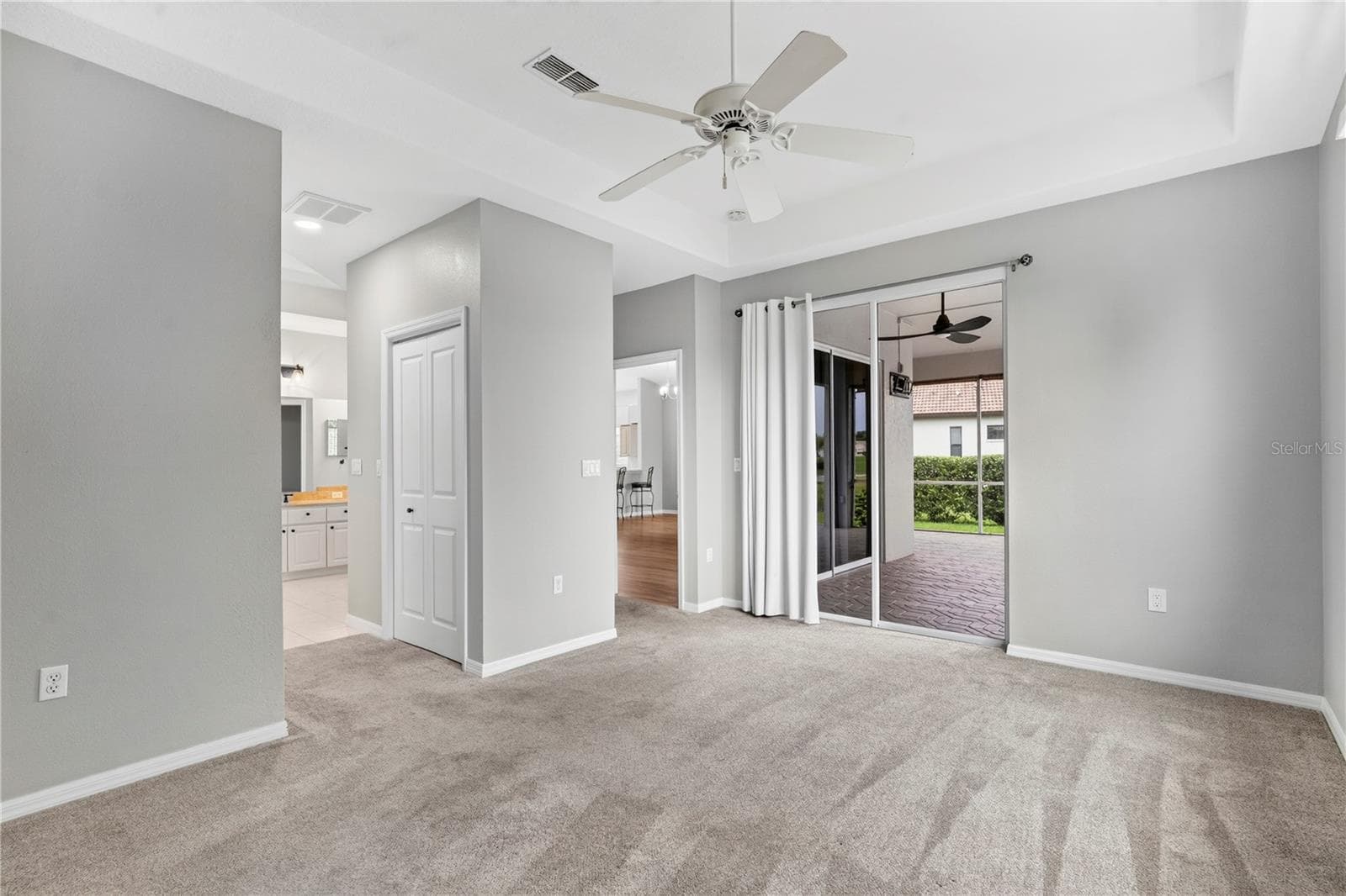 Primary bedroom w/ glass sliding doors to outside enclosed screened patio/lanai - 9257 BONNIE COVE DR, WEEKI WACHEE