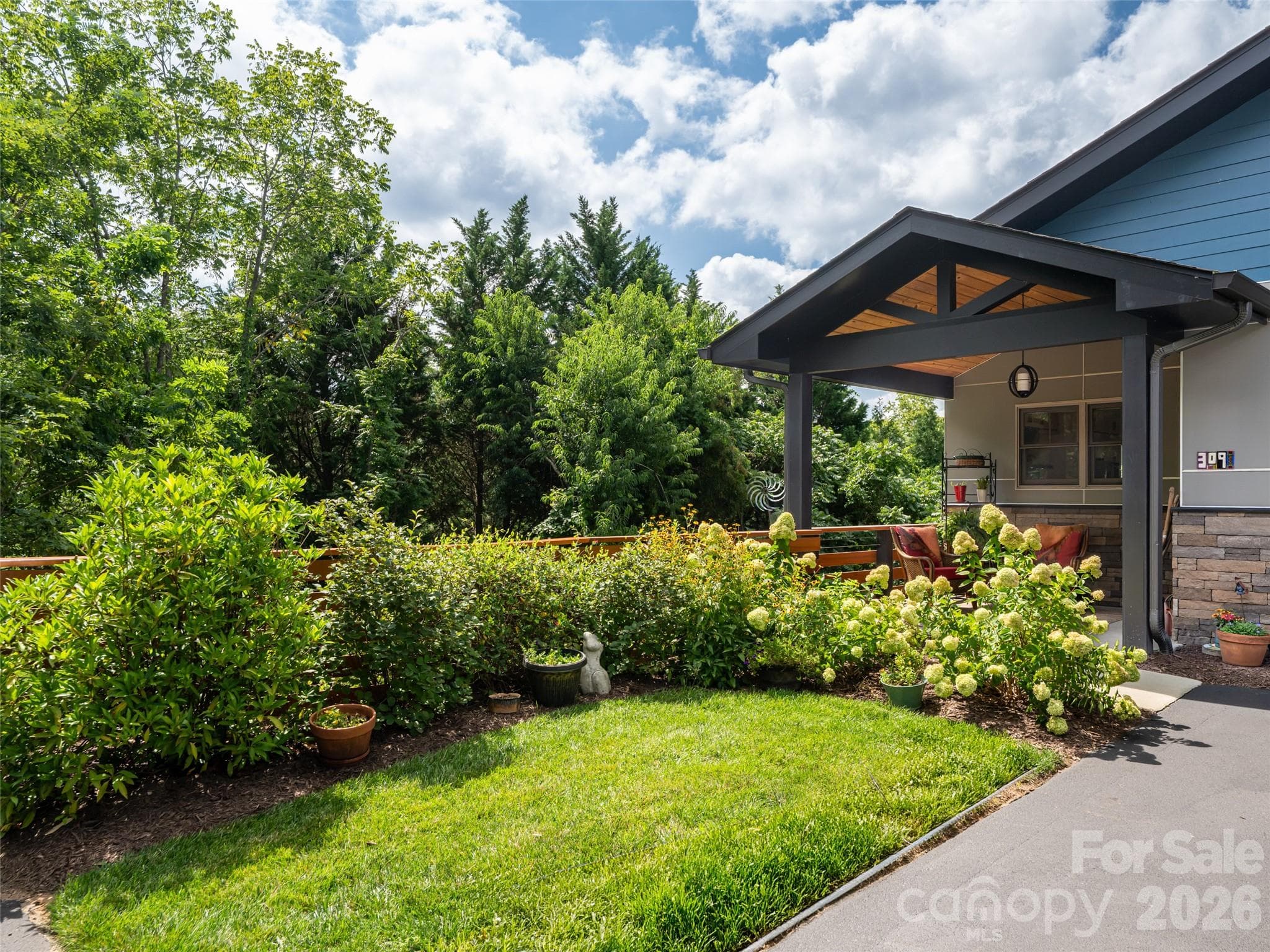 309 Ava Lane is bordered by a lush, green row of trees giving it a "feel" of living in the woods. The current owner loves the privacy. - 309 Ava Lane, Asheville