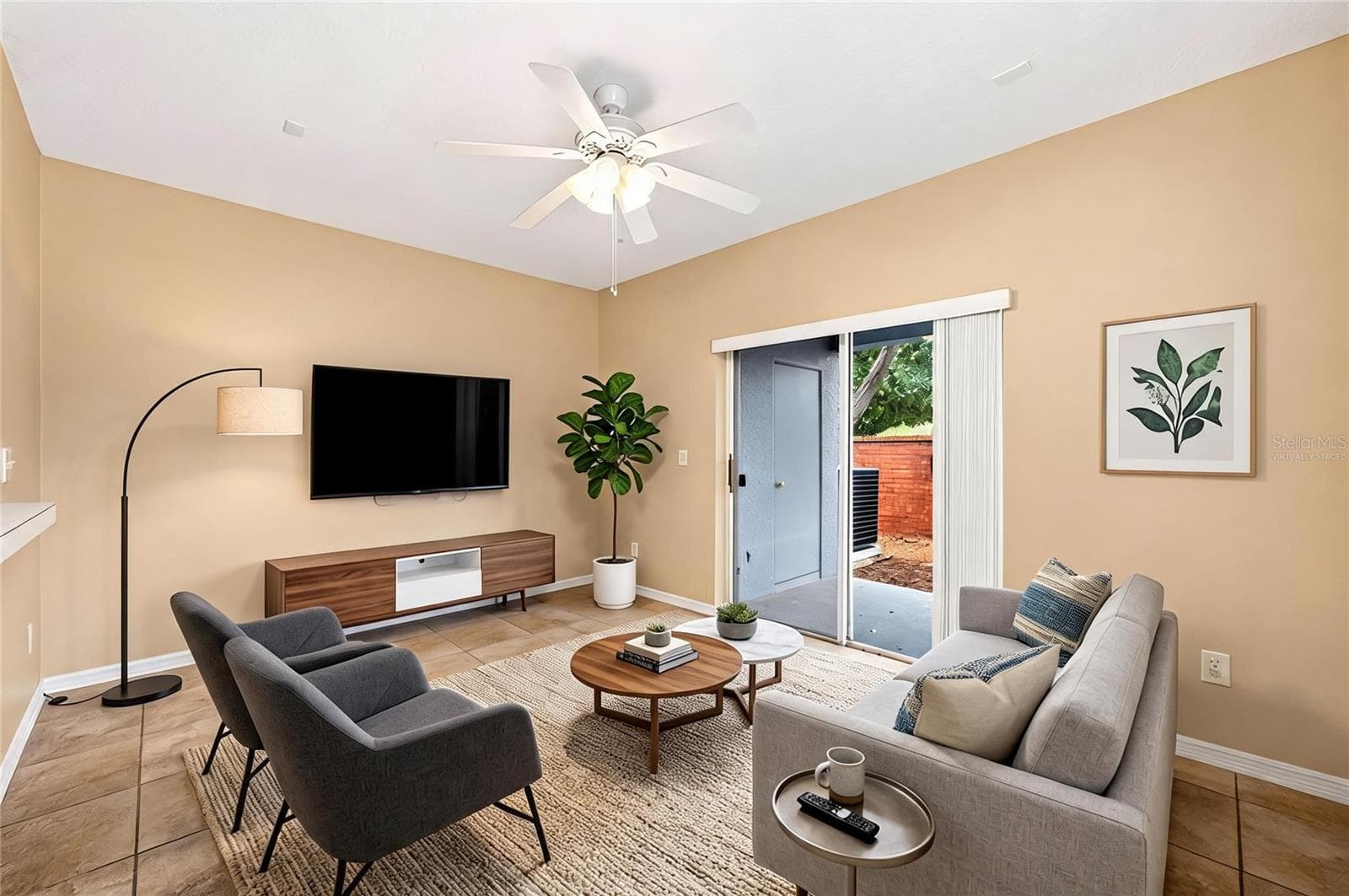 Sliding glass doors open up to a covered lanai. Family room virtually staged. - 102 WILTON CIR, SANFORD