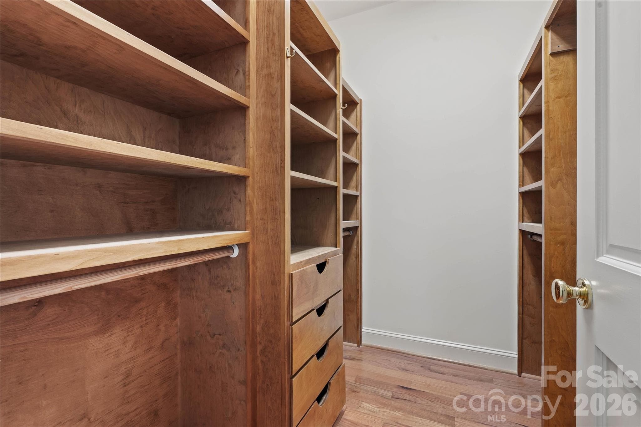 Check out this walk-in primary closet with beautiful wood custom closet shelving and storage. - 675 Heather Drive, Lincolnton
