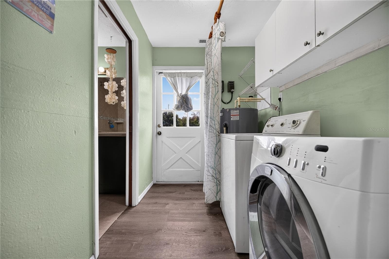 Laundry area with utility sink and storage. - 1305 GREENFIELD CIR, VENICE