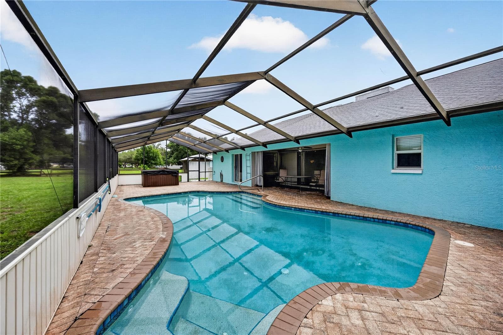 Screen-enclosed pool with brick patio. - 1305 GREENFIELD CIR, VENICE