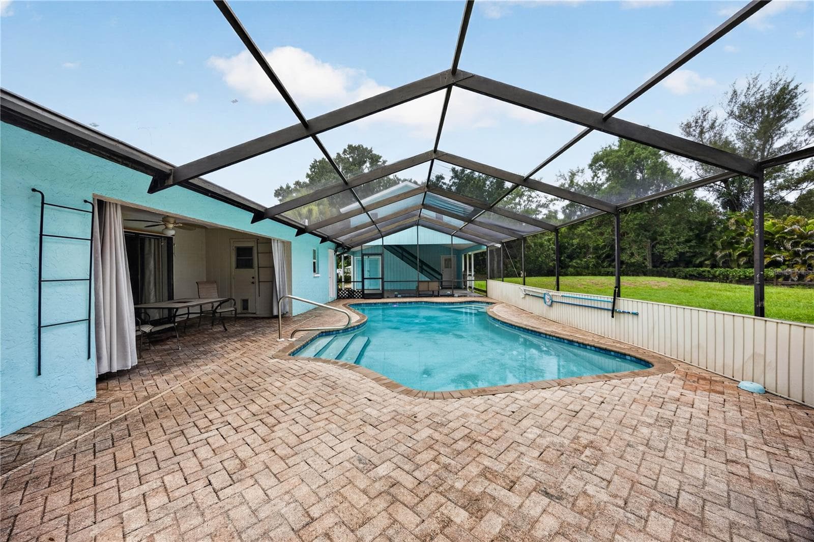 Screened pool with covered seating area. - 1305 GREENFIELD CIR, VENICE