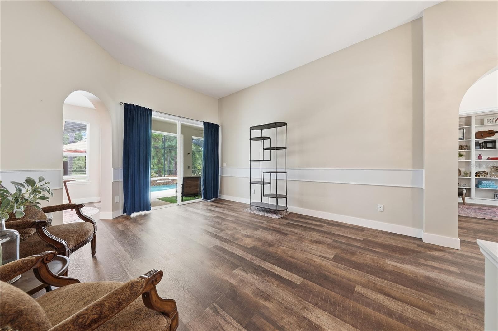 Bright and inviting living area with an open feel and views toward the screened pool and golf course beyond. - 2360 PARK FOREST BLVD, MOUNT DORA