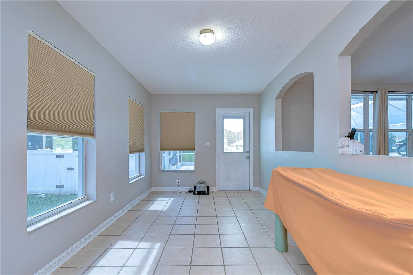 Sunlit bonus/flex room with durable tile flooring, custom window shades, and exterior entry - 11117 RODEO LN, RIVERVIEW