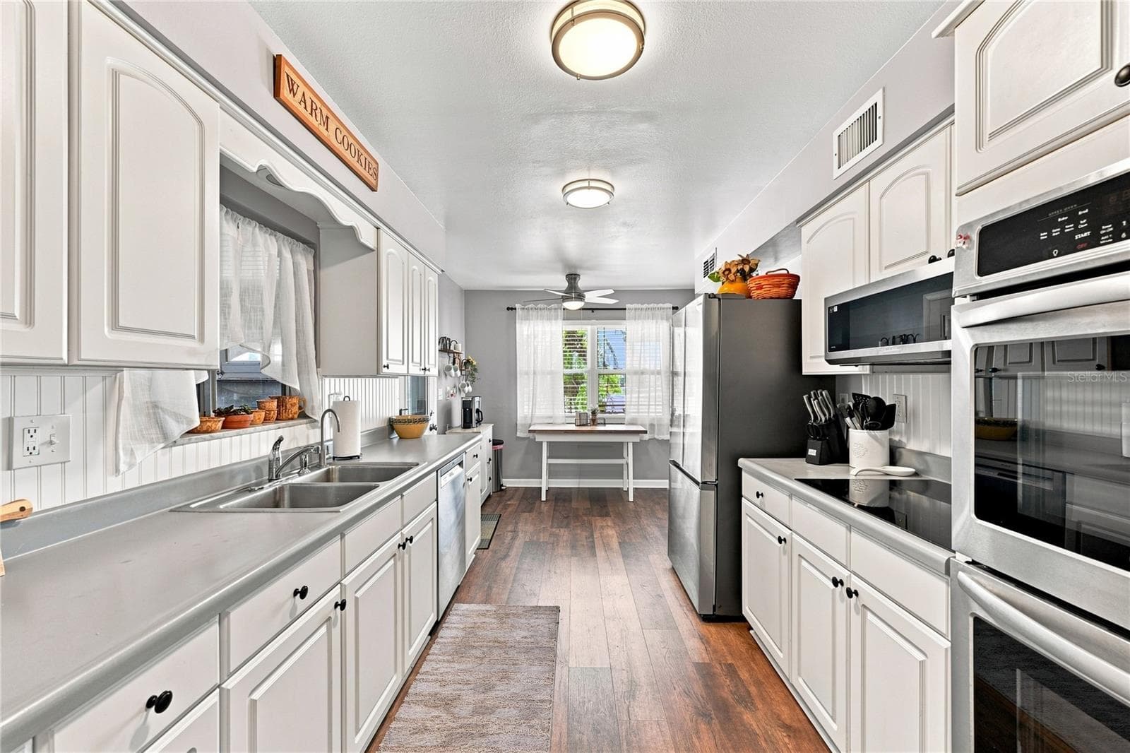 Beautiful Laminate Wood Flooring, Updated Efficient Galley Kitchen, New Fixtures, Interior Repainted, New Refrigerator & Microwave, Double Wall Oven, Coffee Bar, & Eat-In Kitchen - 1405 HACIENDA DR, SUN CITY CENTER