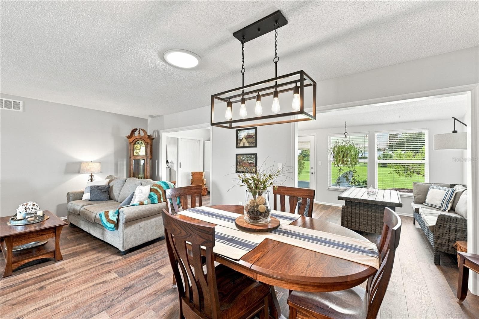 Dining/Living Combo, Beautiful Laminate Oak Plank Flooring New Modern Fixtures, Bright Enclosed Lanai/Florida Room, Solar Tubes, Newer Windows - 1405 HACIENDA DR, SUN CITY CENTER