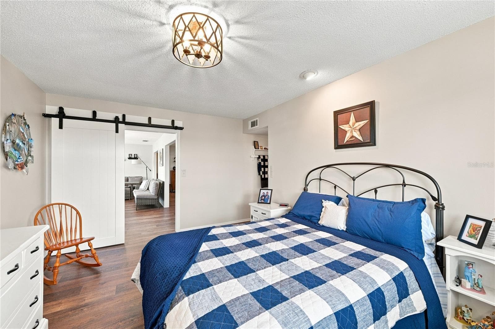 Inviting Primary Bedroom En-Suite Room, Beautiful Laminate Oak Plank Flooring, New Modern Fixture, Sliding Barn Door to Bight Florida Room - 1405 HACIENDA DR, SUN CITY CENTER