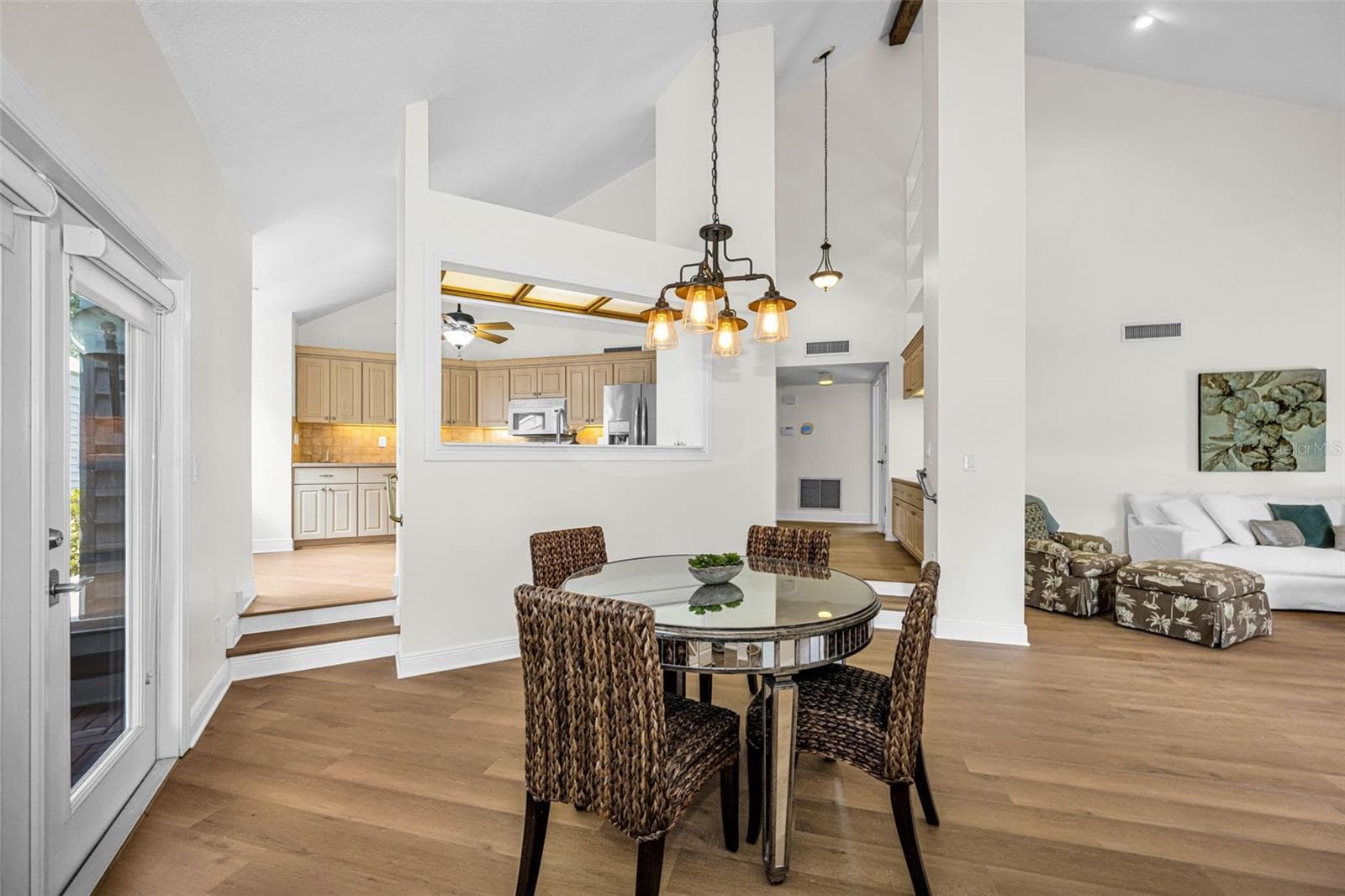 Upon entering you have a large living room, dining room and open kitchen area with volume ceilings and so much natural light. The door to the left is the breezeway which leads to the garage! - 10479 LONGWOOD DR, SEMINOLE