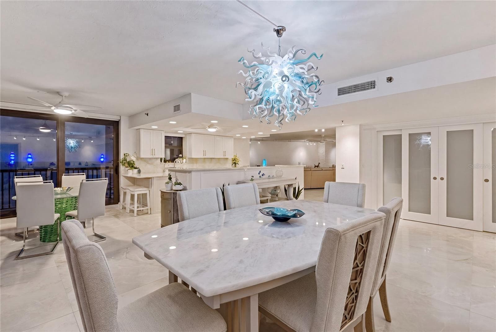 Warm light from the dining area flows into the kitchen with plenty of place to sit and catch up on the day while you prepare a prefect meal. - 1660 GULF BLVD #PH1, CLEARWATER BEACH