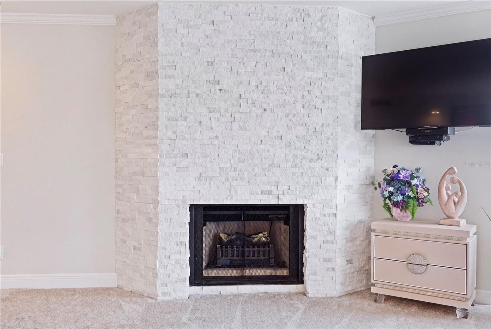 Natural stone facade frames the primary bedroom's fireplace and ties the spaces together. - 1660 GULF BLVD #PH1, CLEARWATER BEACH