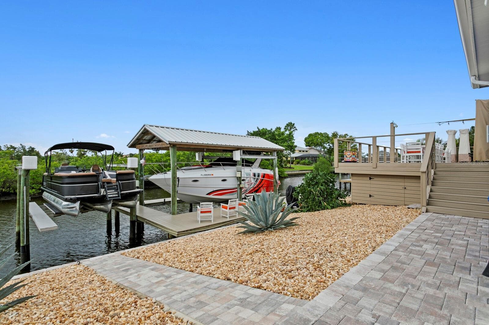 Paver walkway leads from deck down to covered boat lift - 704 EAGLE LN, APOLLO BEACH