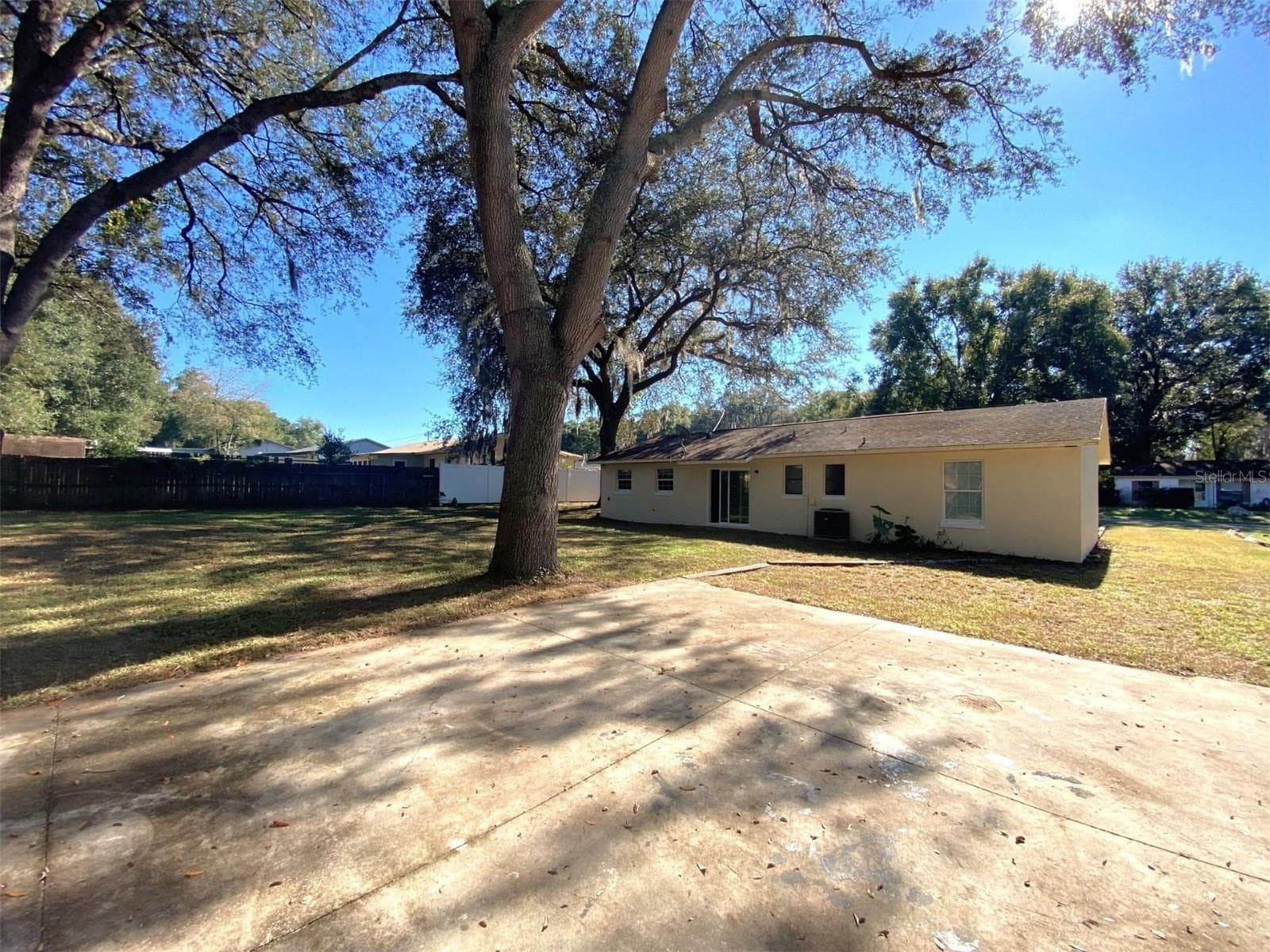 Fenced backyard with drive-thru gate and parking pad in front of accessory building - 11585 SE 129TH LN, OCKLAWAHA