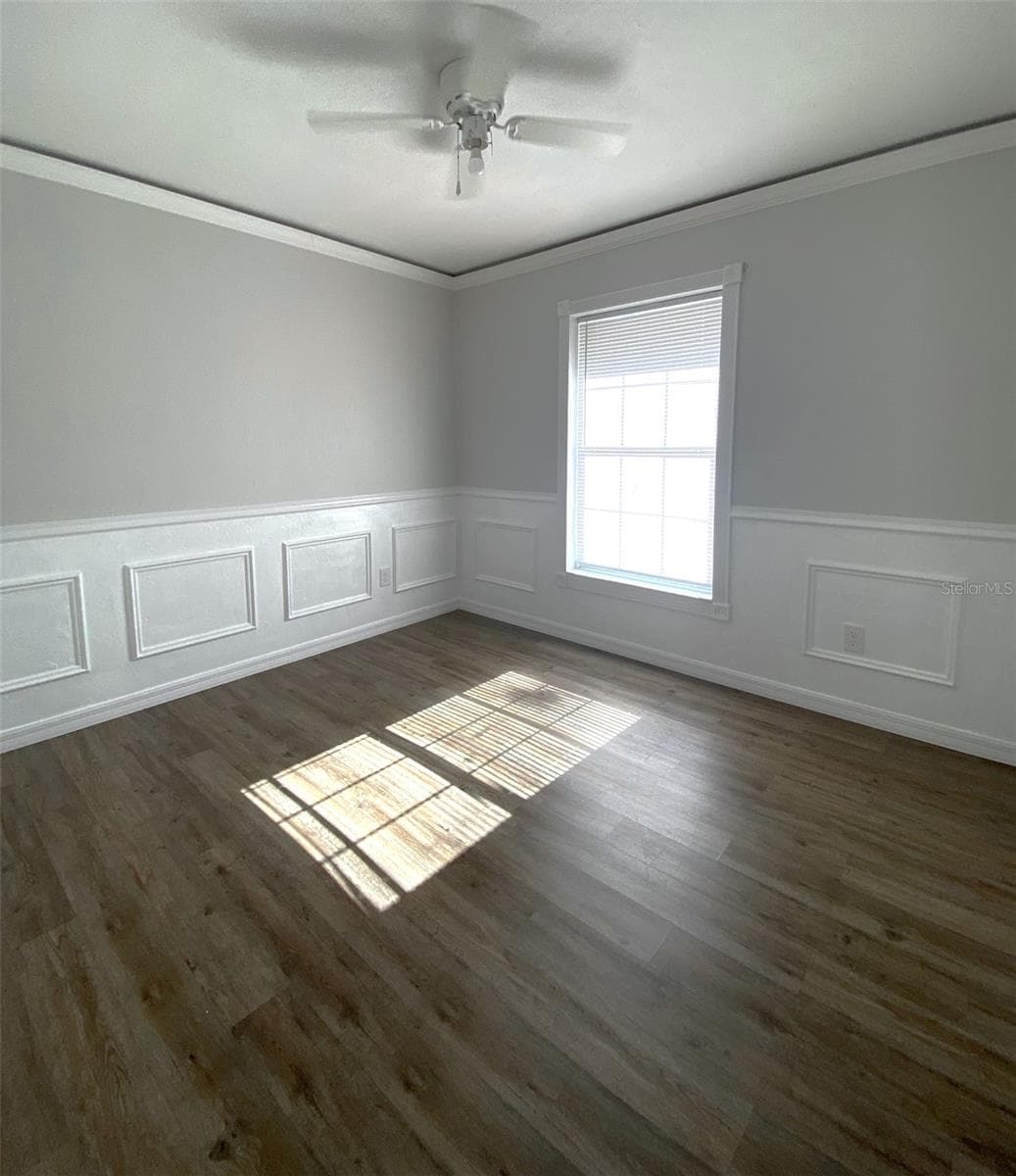 Raised panel wainscoting and ambient lighting hidden behind crown molding create a traditional classic with a modern twist. Who's bedroom is this? - 11585 SE 129TH LN, OCKLAWAHA