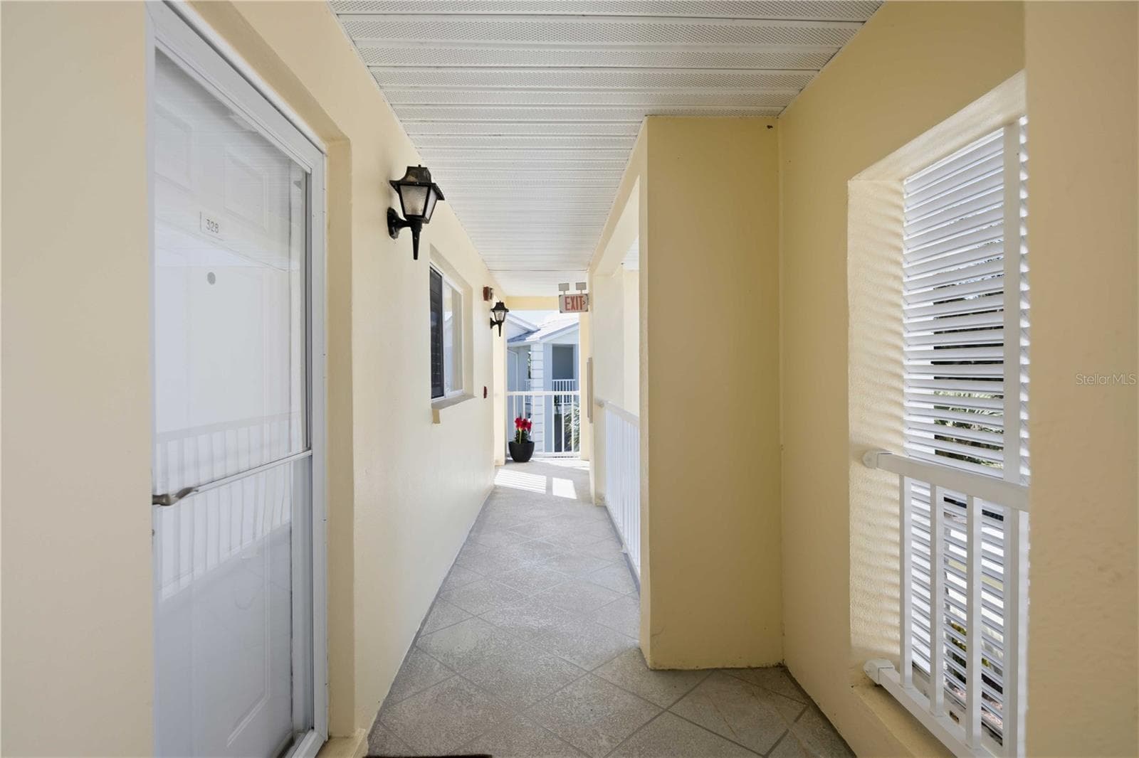 Bright, covered exterior corridor leading to the residence. - 406 CERROMAR CIR N #328, VENICE