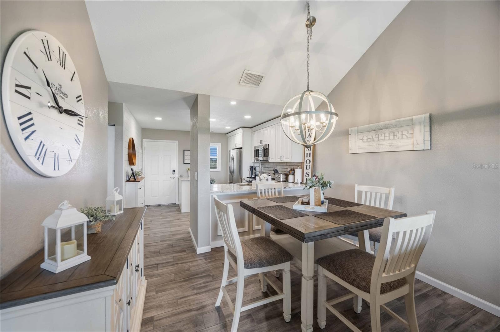 Light-filled dining space features vaulted ceilings and an eye-catching contemporary chandelier. - 406 CERROMAR CIR N #328, VENICE
