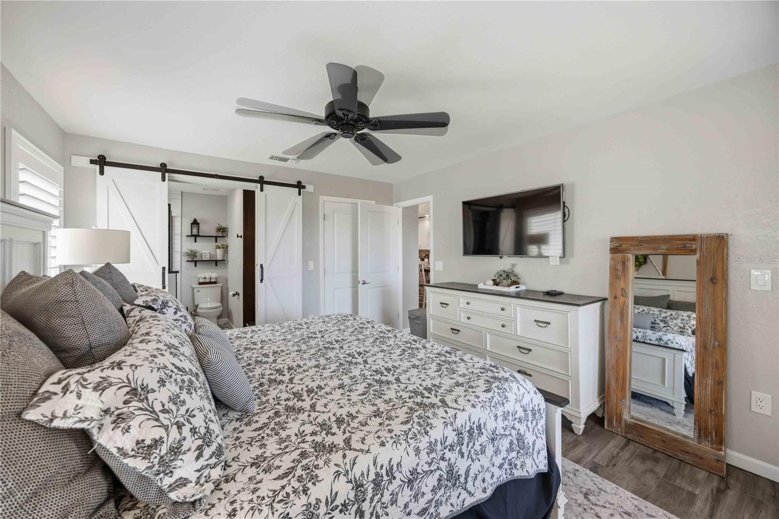 Another view of the primary suite highlights its comfortable scale and stylish barn-door detail. - 406 CERROMAR CIR N #328, VENICE