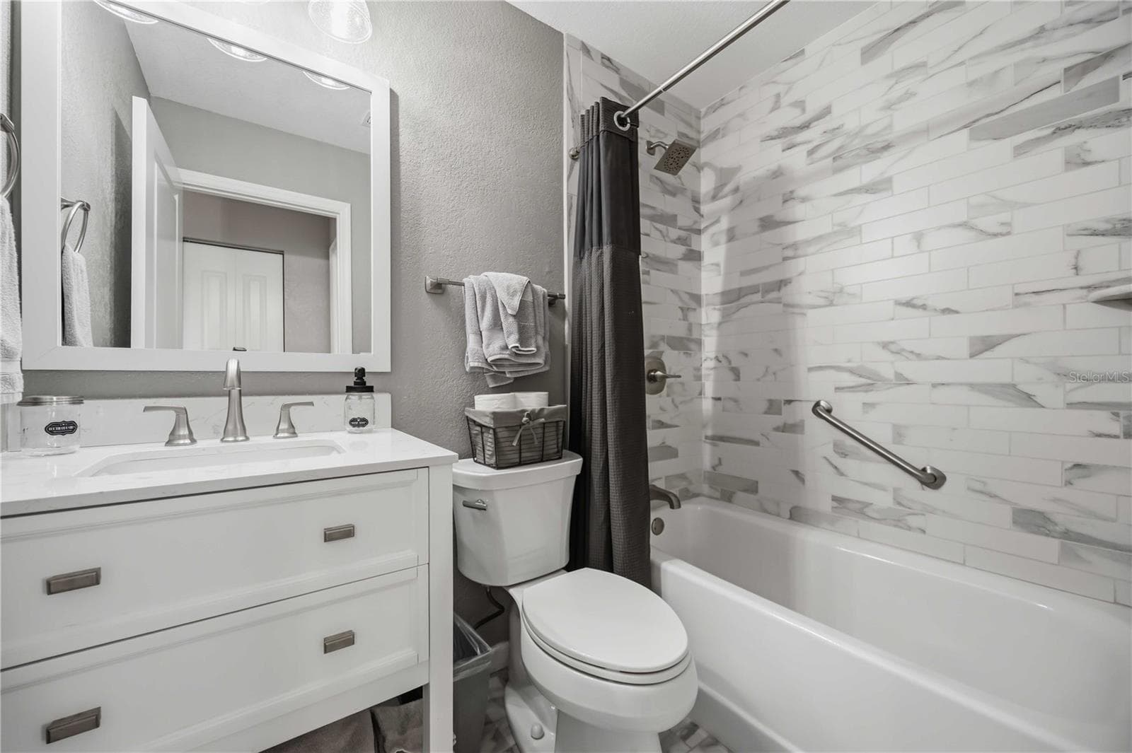 Updated guest bath features a clean white vanity and a beautifully tiled tub-and-shower surround. - 406 CERROMAR CIR N #328, VENICE