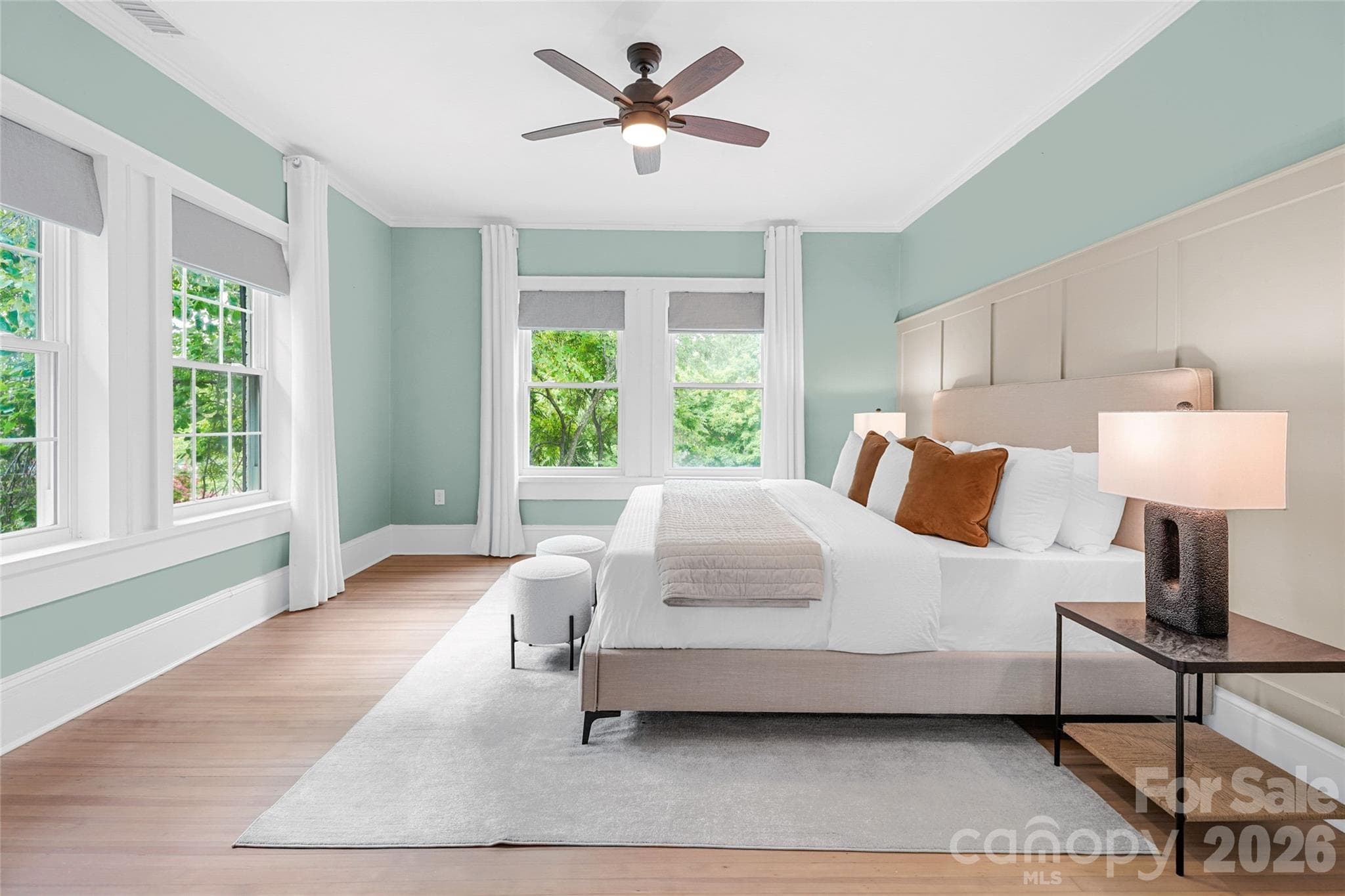 Spacious primary bedroom with hardwood floors and room to unwind. - Charlotte