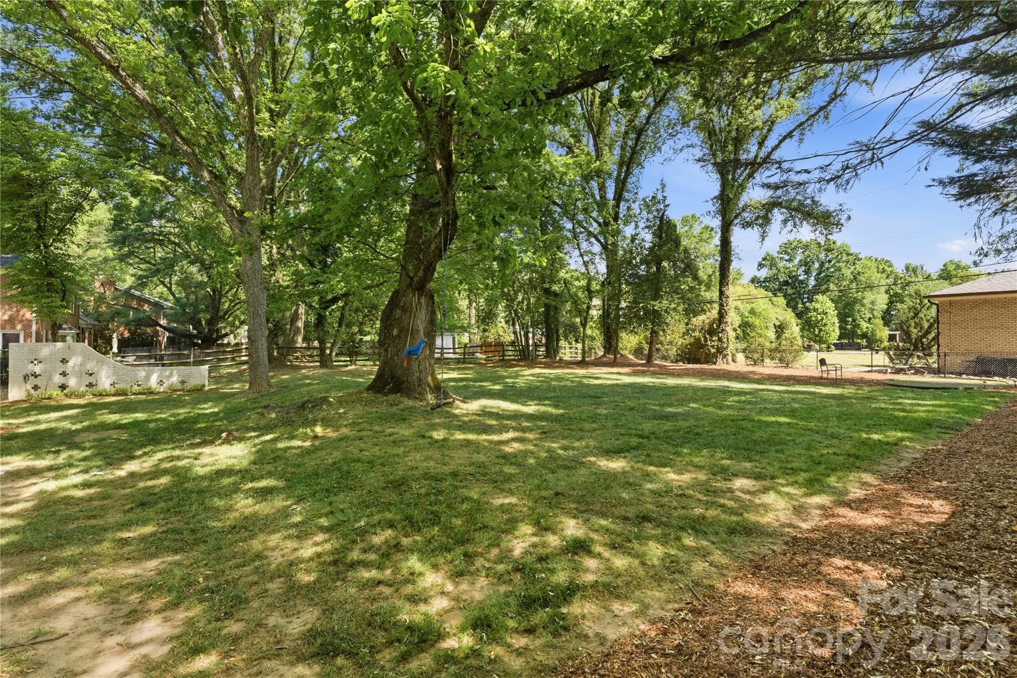 Expansive half-acre backyard surrounded by mature trees. - Charlotte