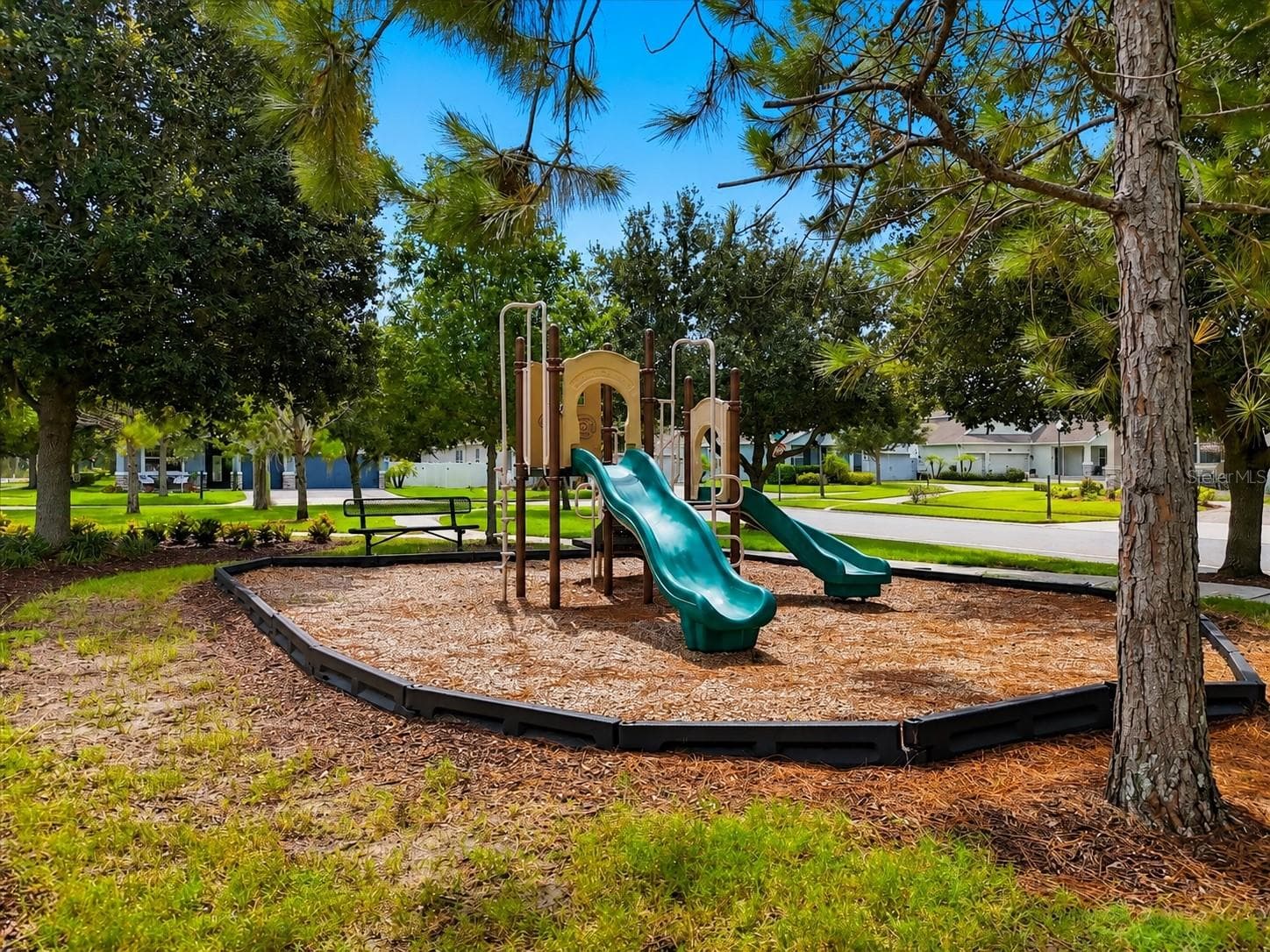 Enjoy a welcoming community playground nestled beneath mature trees, offering a charming outdoor space for play, connection, and everyday neighborhood moments. - 4791 RIVERWALK DR, ST CLOUD