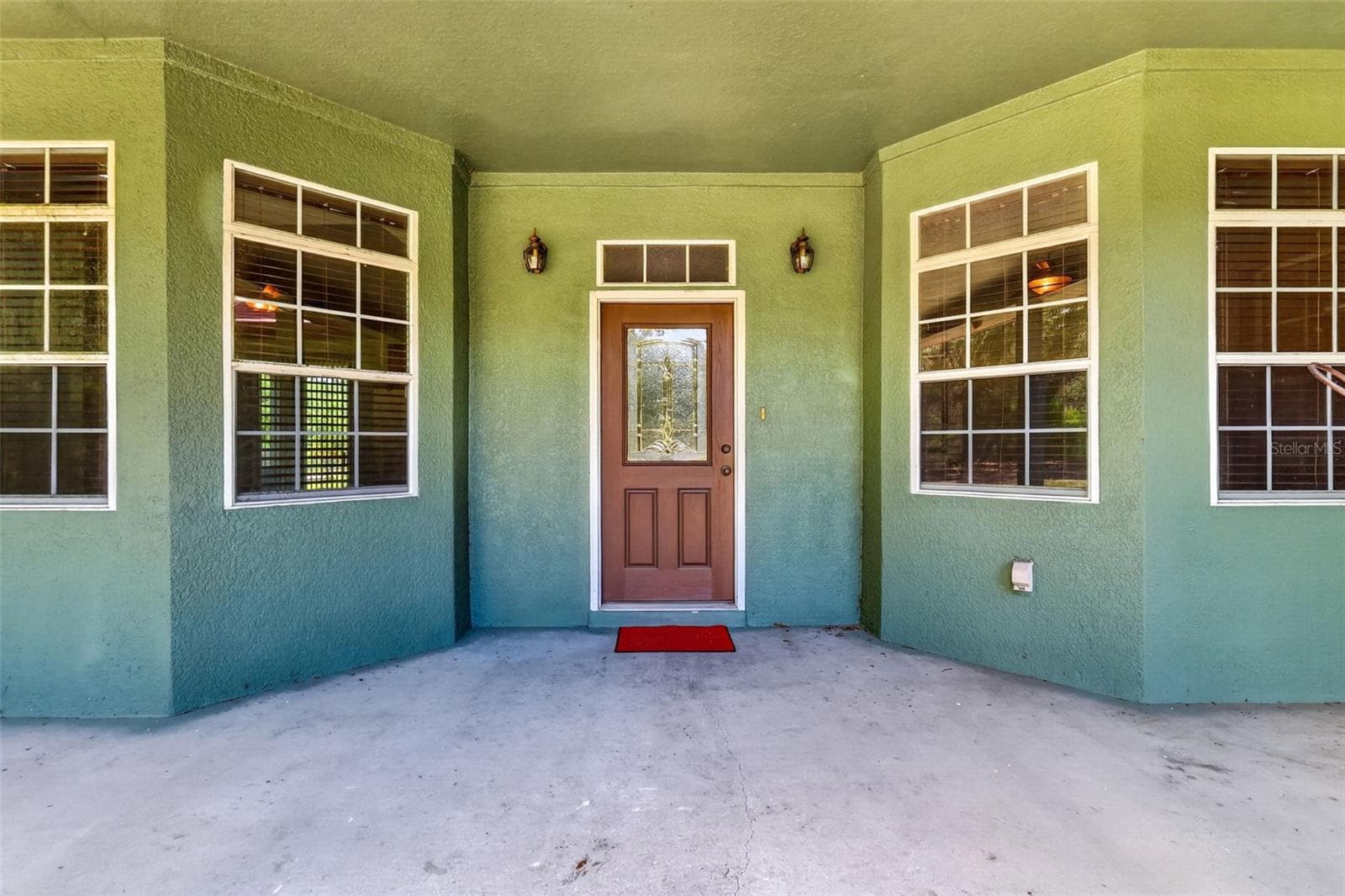 A welcoming covered entry with a decorative glass door and charming coach lanterns sets the tone for the warmth inside. - 4617 ROUND LAKE RD, APOPKA
