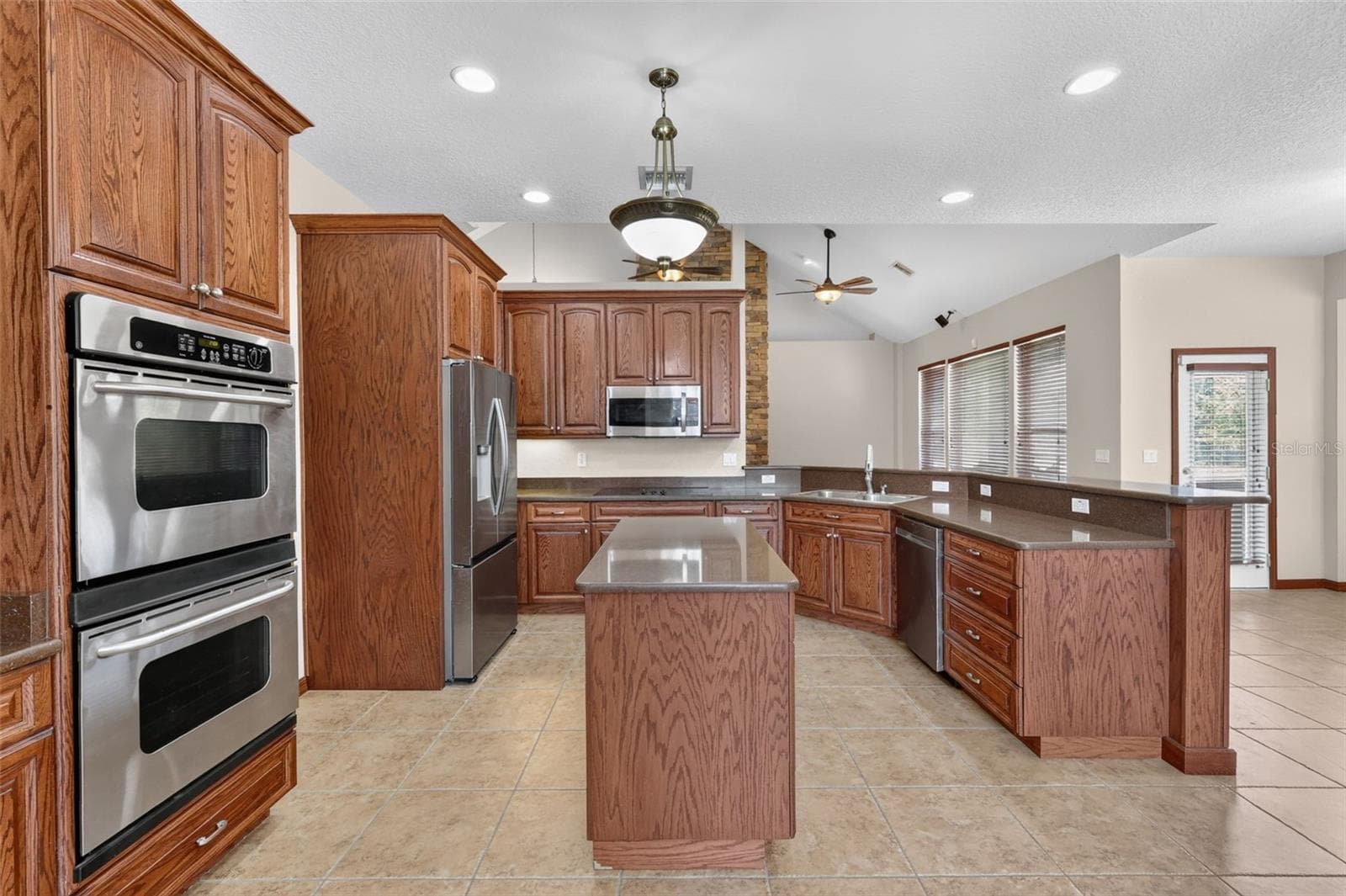 Double wall ovens, a full-size stainless refrigerator, and generous counter space make this kitchen ready for everything from weeknight dinners to holiday feasts. - 4617 ROUND LAKE RD, APOPKA