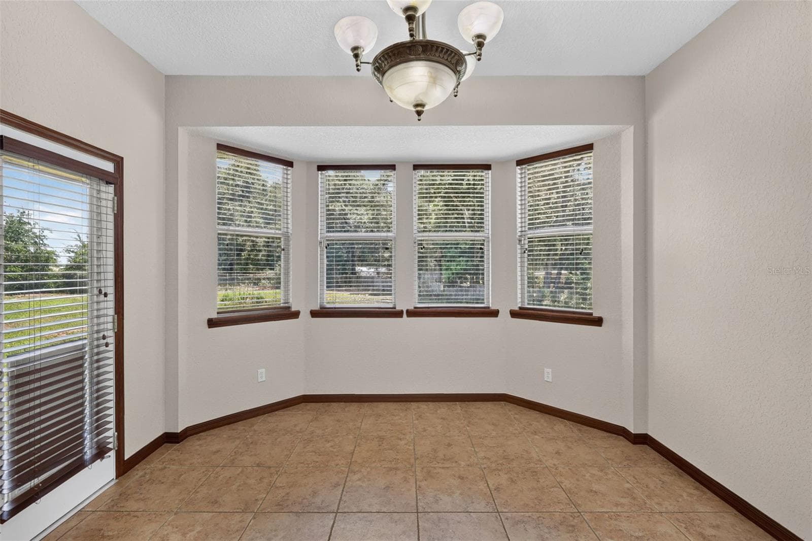 A charming breakfast nook bathed in natural light from a beautiful bay window, with direct access to the outdoors. - 4617 ROUND LAKE RD, APOPKA