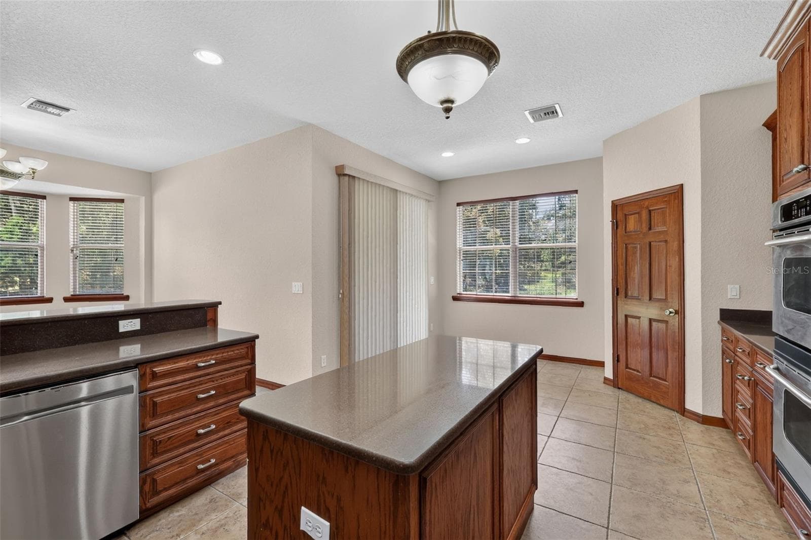 Every detail in this kitchen was designed for functionality: a stainless dishwasher, double ovens, walk-in pantry, and direct backyard access. - 4617 ROUND LAKE RD, APOPKA