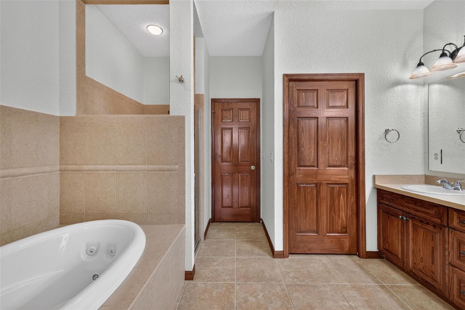 This spa-like primary bathroom has room to breathe, with a jetted tub, separate shower, and plenty of storage. - 4617 ROUND LAKE RD, APOPKA
