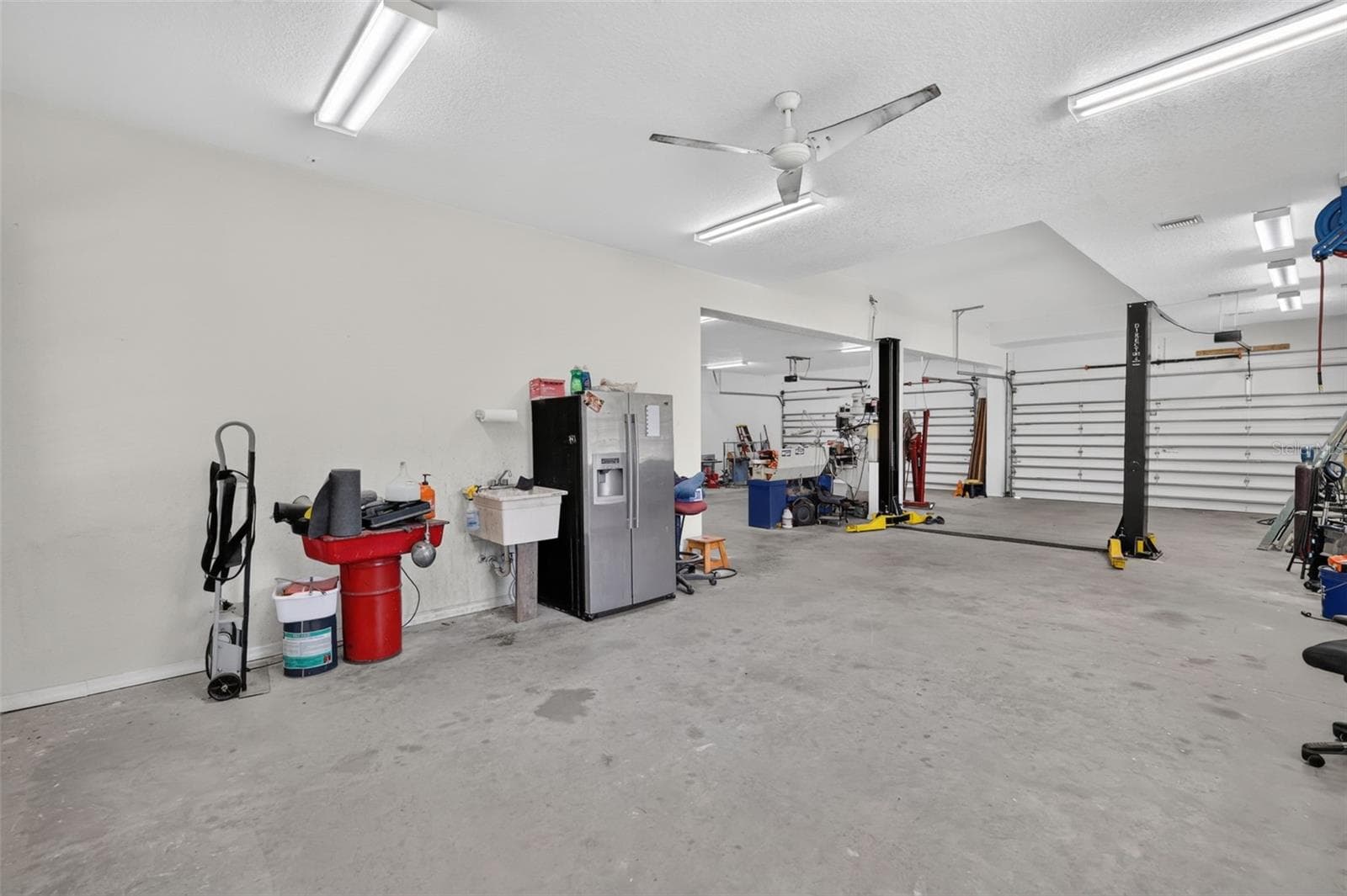 Multiple garage doors, a utility sink, industrial fans, and abundant electrical service make this workshop a dream for any trade or hobby. - 4617 ROUND LAKE RD, APOPKA
