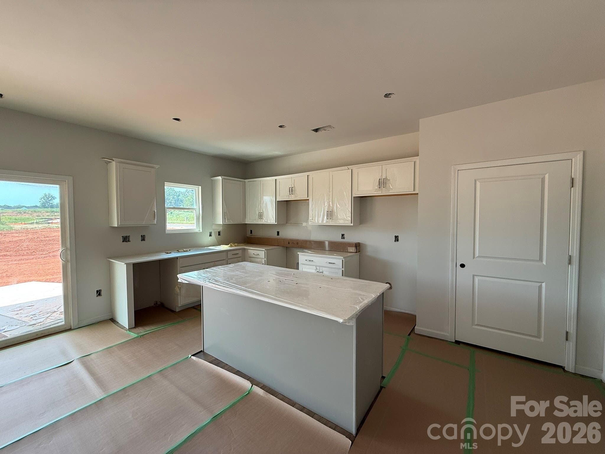 Kitchen features white surround cabinets and a gray island - Charlotte