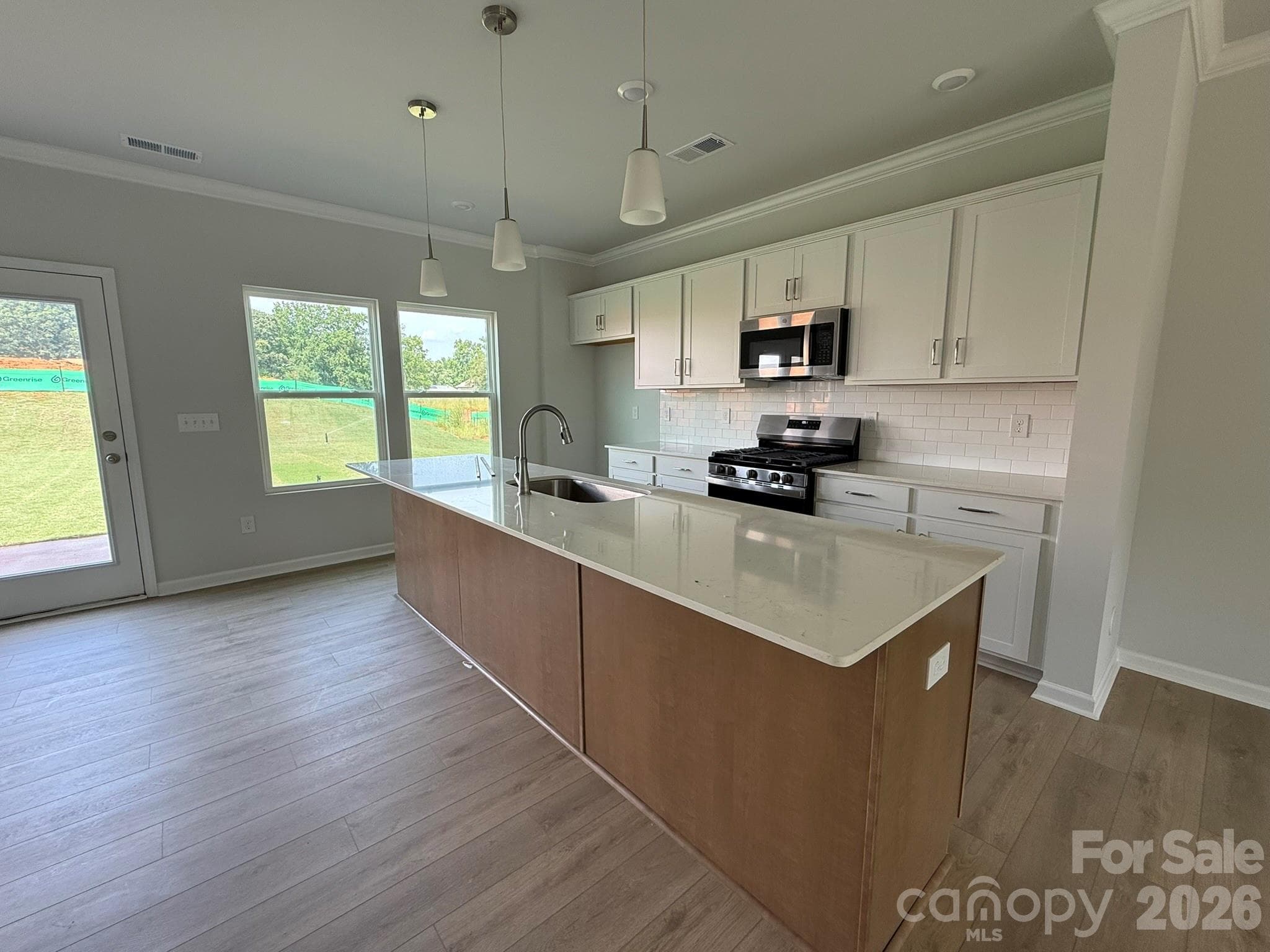 Kitchen features White Surround Cabinets and Brown Island with Quartz Countertops - 1231 Bansal Drive, Charlotte
