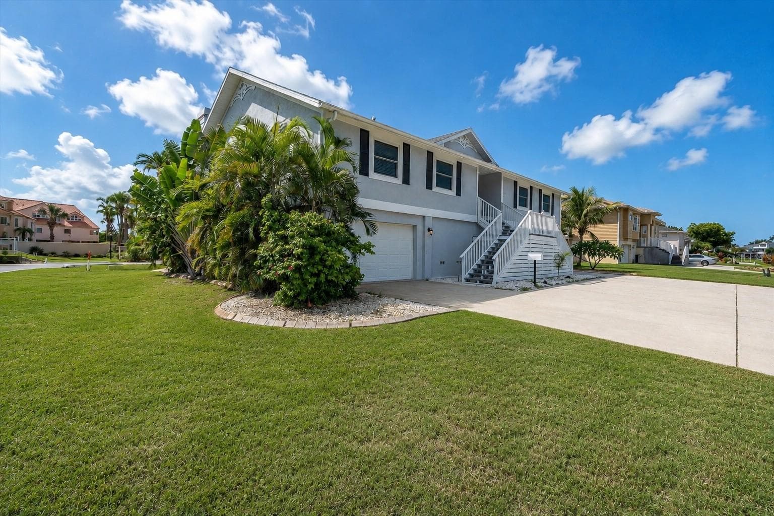 Expansive corner property beautifully framed by lush, mature tropical trees and landscaping. - 6501 MOCKINGBIRD WAY S, GULFPORT