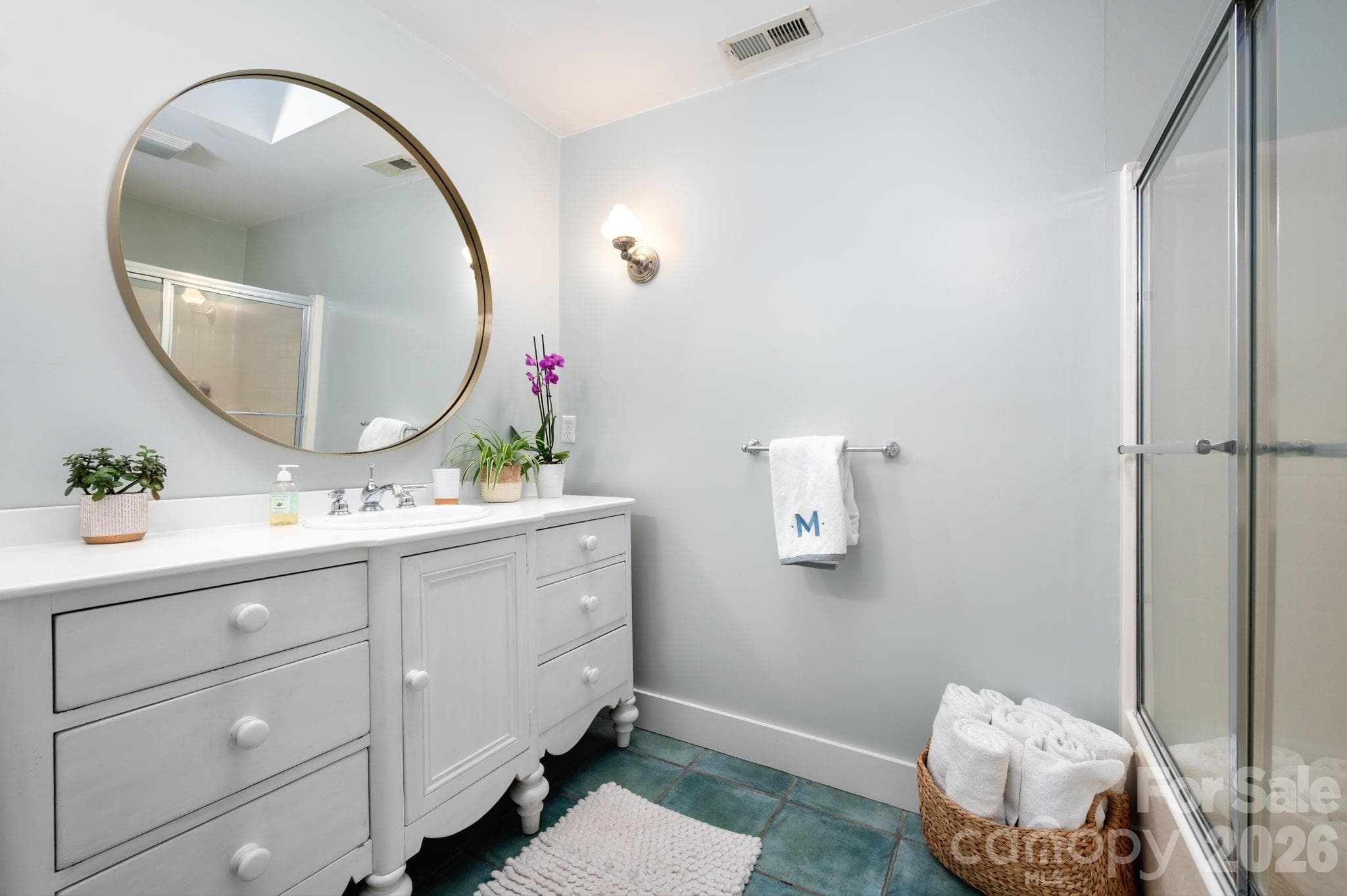 Main level bathroom has ceramic tile, skylight, bath, shower combo, and large vintage painted vanity - 183 Blarney Road, Lake Lure