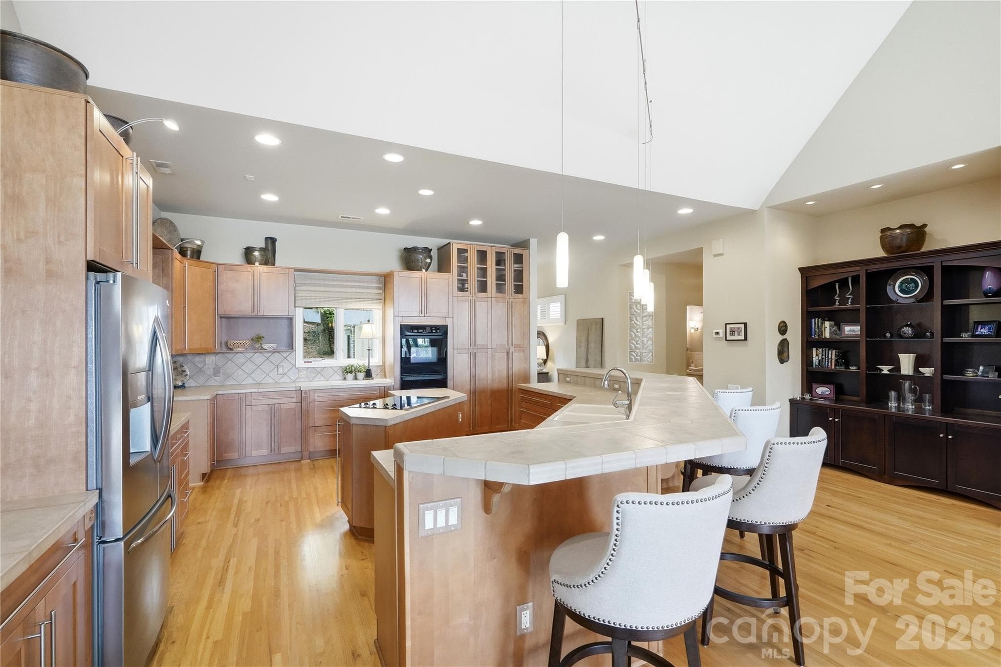 Equipped with stainless steel appliances, a center island, and a breakfast bar - 1075 Lakefront Woods Drive, Belmont
