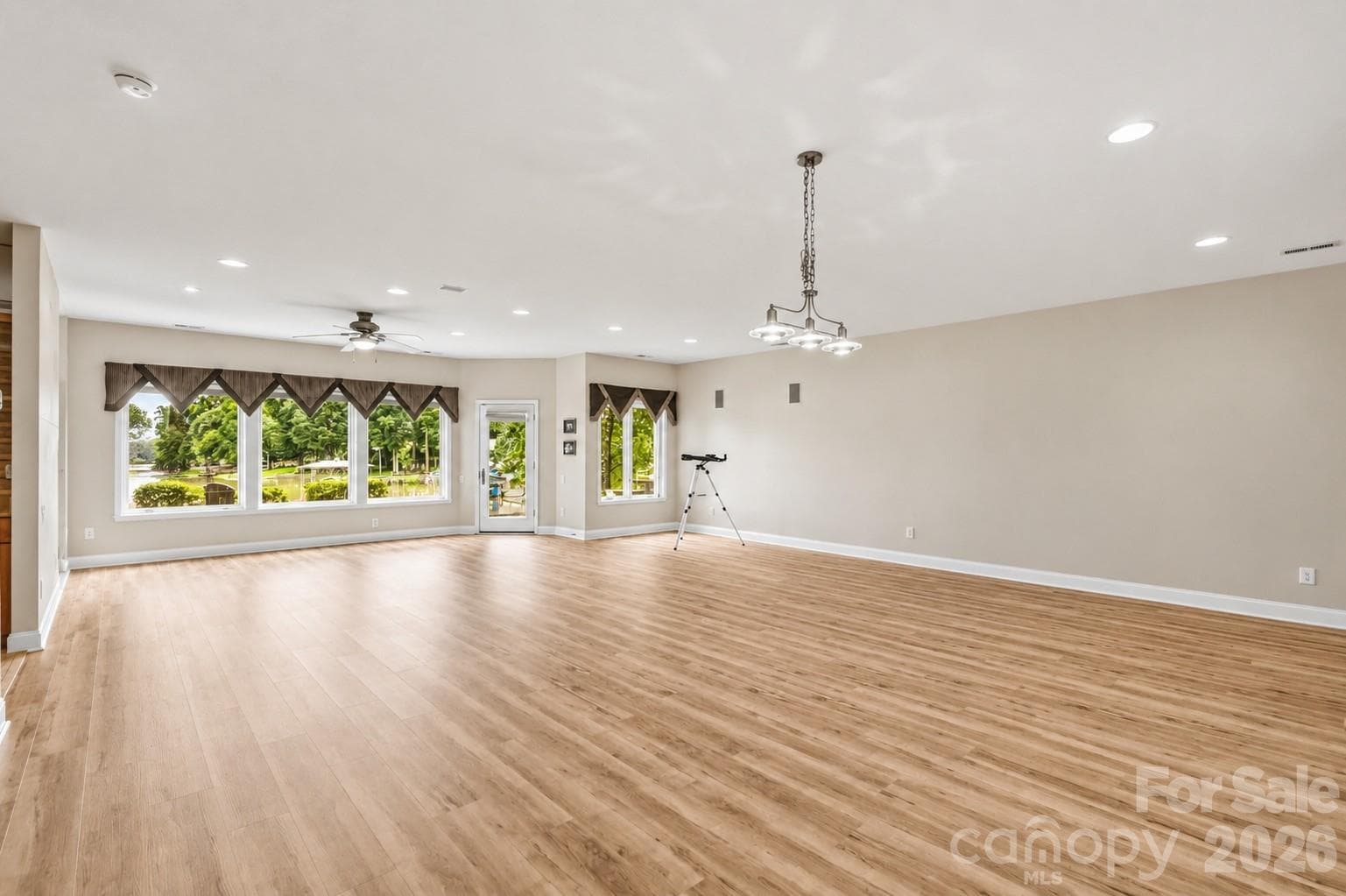 Massive lower-level recreation room with surround sound speakers and second fireplace—ideal for game tables and media lounge - 1075 Lakefront Woods Drive, Belmont
