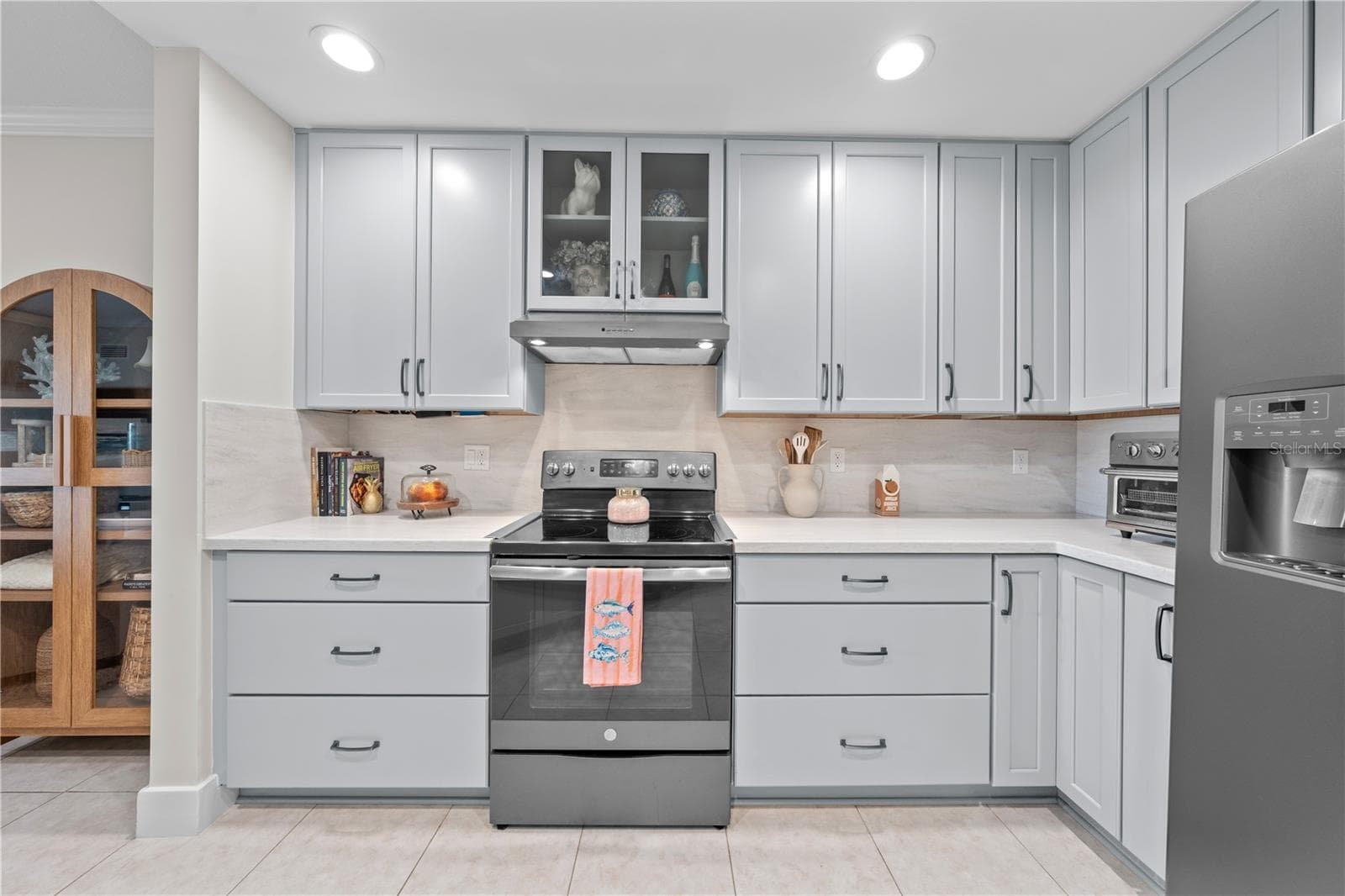 Kitchen features showcase cabinets, quartz countertops and stainless appliances. - 13570 MYSTIC DR #102, SEBASTIAN