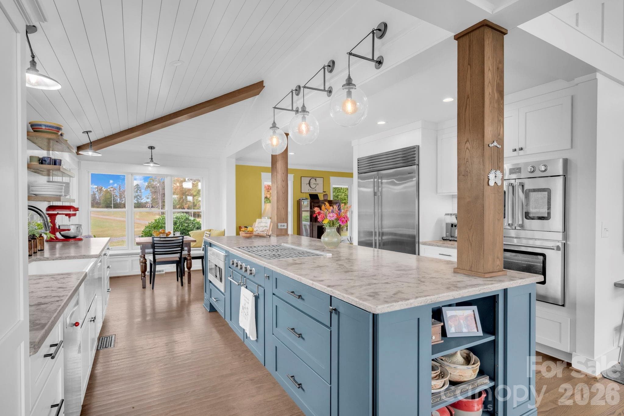 4-chair breakfast island w/ wood columns and display shelves, pantry cabinet w/ pull-out drawers, under cabinet lighting, and cathedral and vaulted shiplap ceilings w/ suspended beams - 1260 Beaver Island Trail Road, Walnut Cove