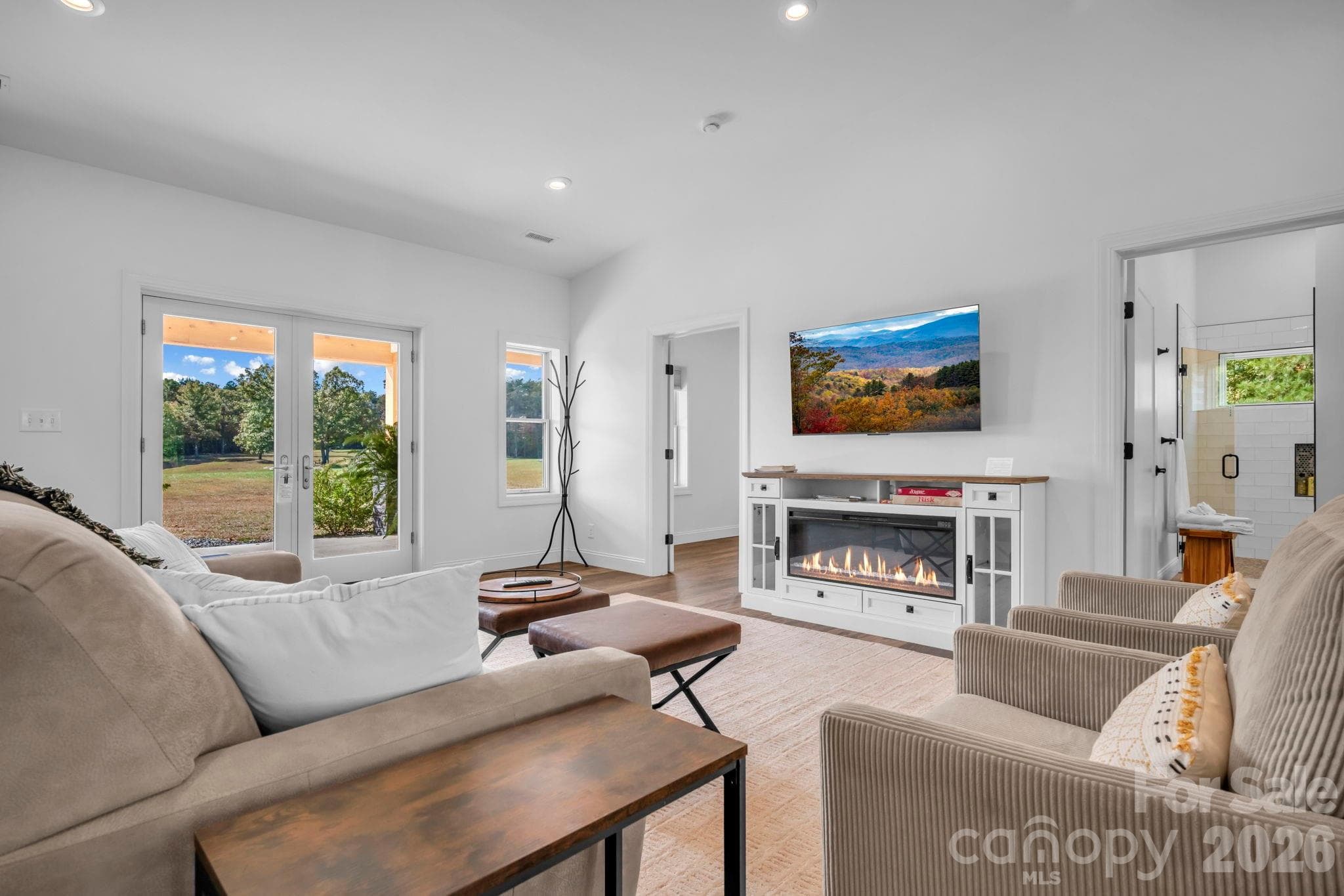 Living room w/ built in electric fireplace cabinet, LVP flooring throughout, and cathedral ceilings - 1260 Beaver Island Trail Road, Walnut Cove