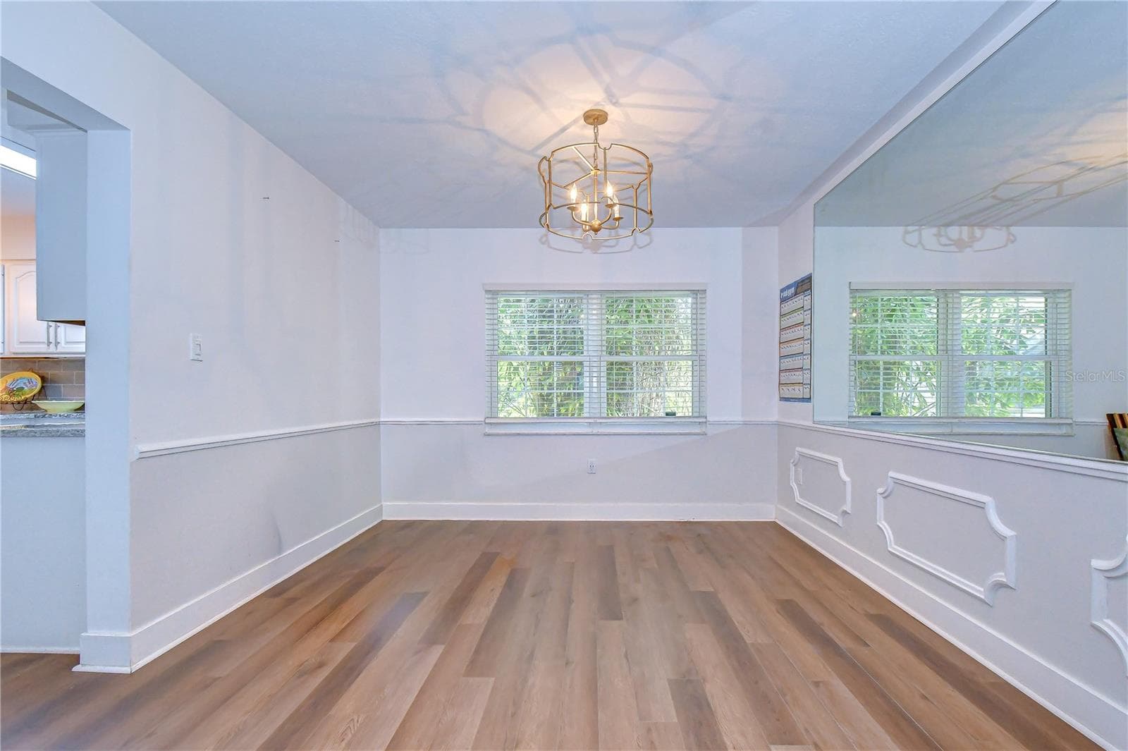 Formal dining room with classic wall trim and modern chandelier. - 901 WOODVIEW DR, BRANDON