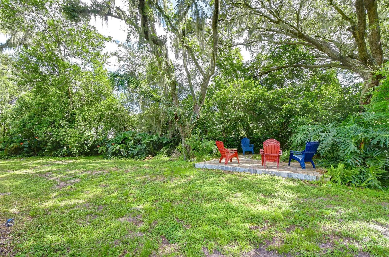 Charming fire pit tucked among mature trees provides a cozy setting for evenings outdoors - 901 WOODVIEW DR, BRANDON