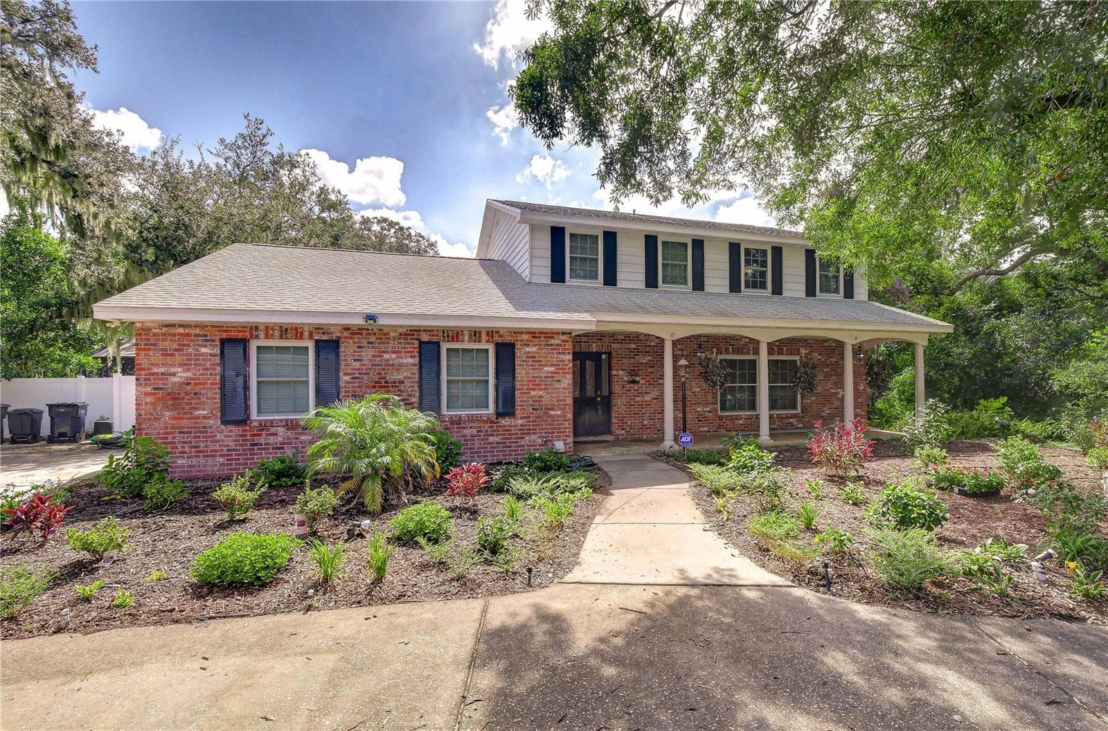 Front exterior view showing covered porch and manicured front lawn. - 901 WOODVIEW DR, BRANDON