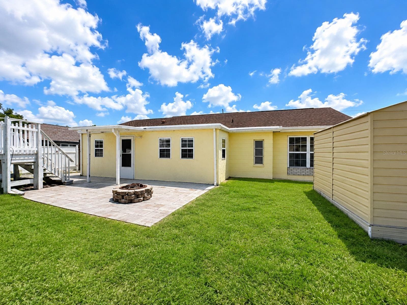 Virtual enhance: grass look greener and healthier, refresh and brighten the exterior paint. ROOF IS NEW 2026. Backyard with Fire Pit - 3153 MOOG RD, HOLIDAY