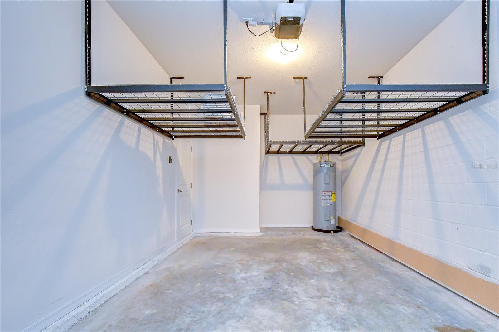 Attached garage with elevated rack storage system. - 3326 PLEASANT WILLOW CT, BRANDON